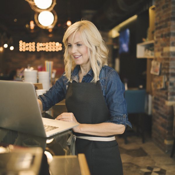 Coffee shop owner working on laptop