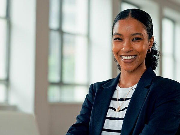 Professional woman smiling while wearing business attire and looking at the camera